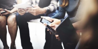 Employees using phones, tablets, laptops.